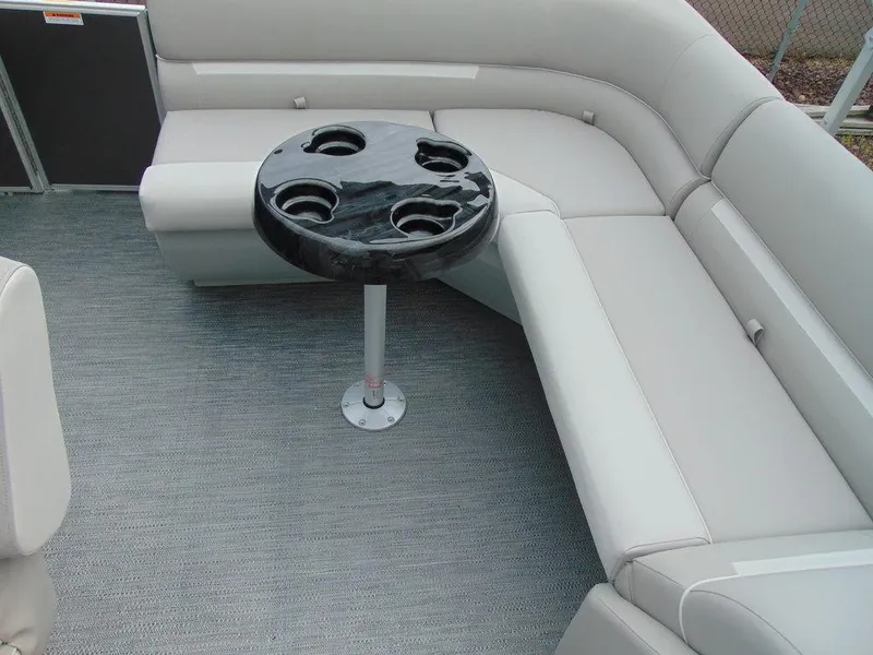 Slide: The Image of 2024 Godfrey Xperience 1880 CX boat interior with gray seating and round table. - 9