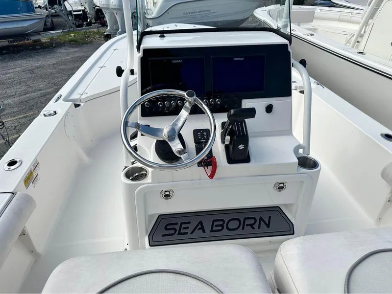 Slide: The Image of 2022 Sea Born FX24 boat console with steering wheel and dual screens. - 2