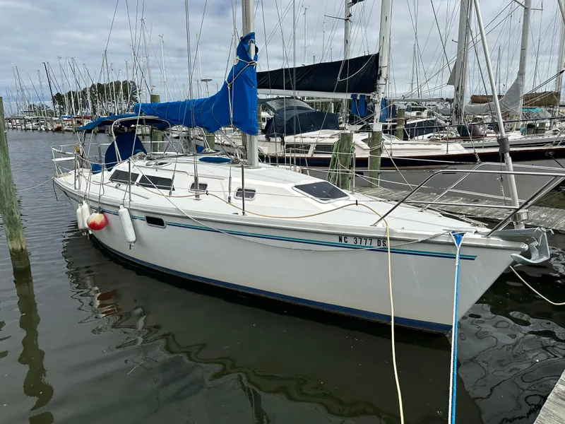 The Image of 1994 Catalina 320 sailboat docked in a marina, featuring blue sail covers. - 1