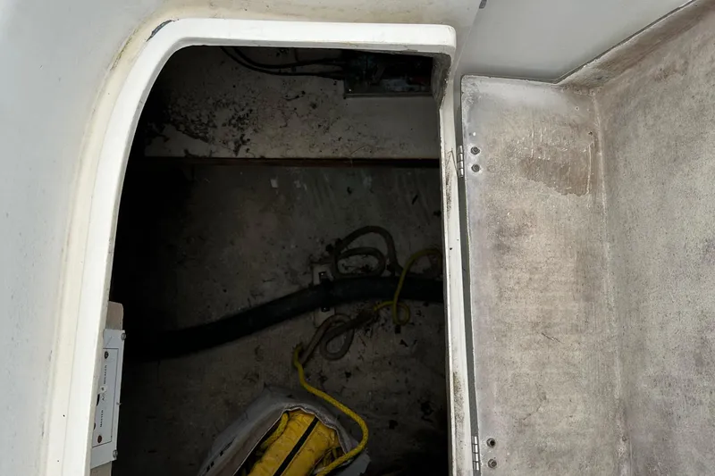 Slide: The Image of Compartment interior of a 1994 Catalina 320 sailboat, showing storage space and equipment. - 11