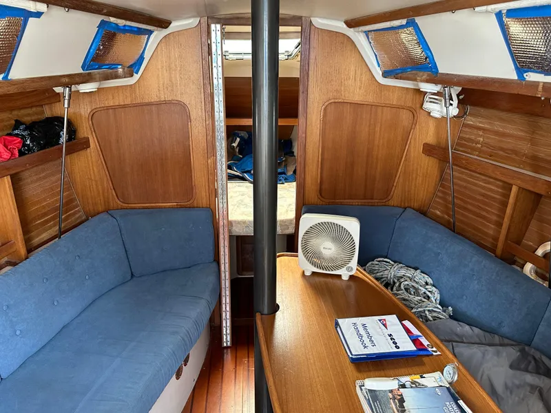 Slide: The Image of Interior of a 1994 Catalina 320 sailboat with blue seating and wooden accents. - 15