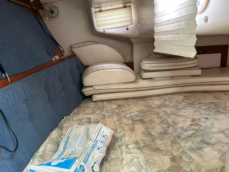 Slide: The Image of Interior of a 1994 Catalina 320 sailboat with cushions and a floral-patterned mattress. - 17