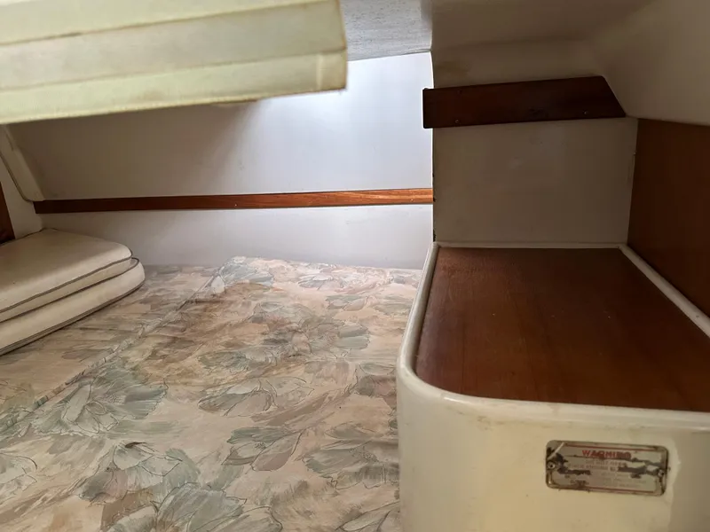 Slide: The Image of Interior cabin of a 1994 Catalina 320 sailboat with wood accents and patterned flooring. - 18