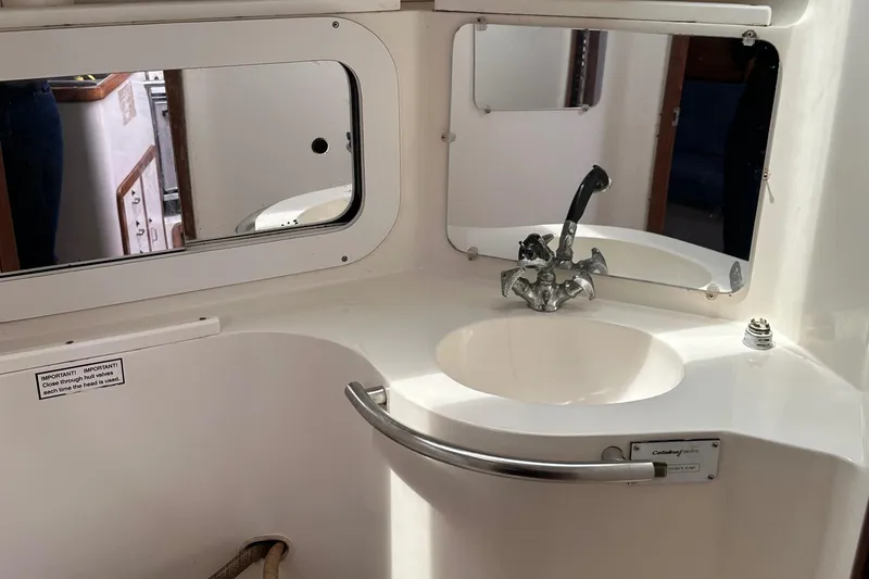 Slide: The Image of 1994 Catalina 320 yacht bathroom with sink, mirror, and chrome fixtures. - 23