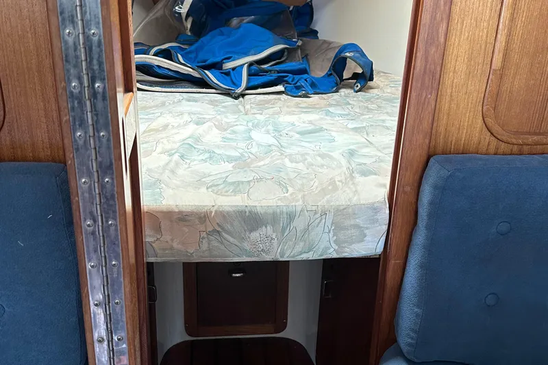 Slide: The Image of Interior cabin of a 1994 Catalina 320 sailboat with a floral-patterned bed. - 24
