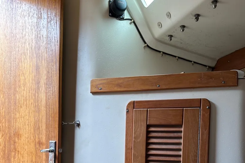 Slide: The Image of Interior of a 1994 Catalina 320 sailboat with wooden door and paneling. - 25