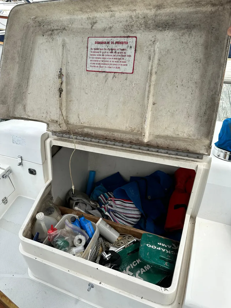 Slide: The Image of Open storage compartment on 1994 Catalina 320 sailboat, containing various boating supplies and equipment. - 28