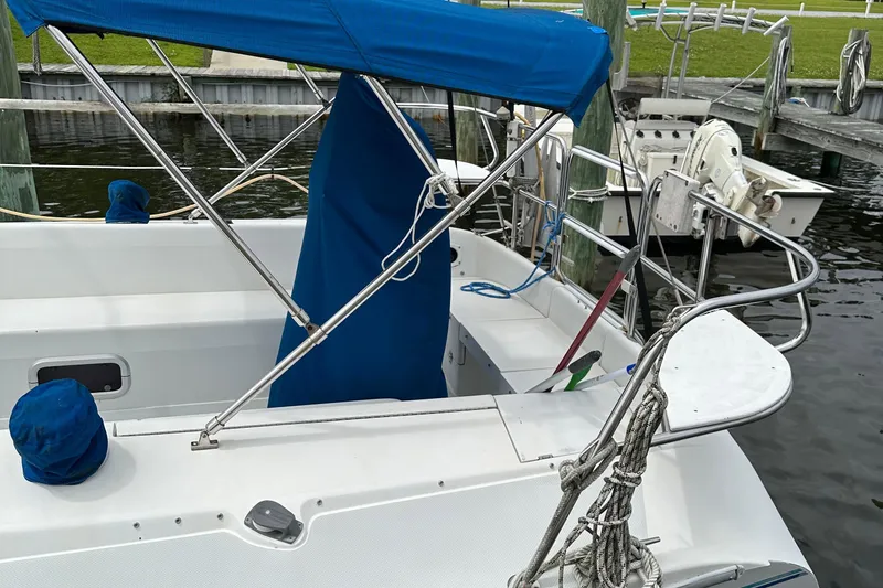 Slide: The Image of 1994 Catalina 320 sailboat with blue canopy docked at marina. - 8