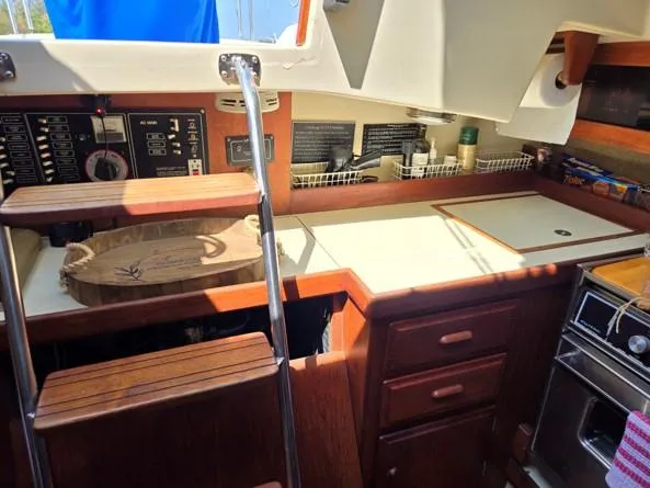Slide: The Image of Interior of 1986 O'Day 35 sailboat showing kitchen area with wooden cabinetry and appliances. - 11