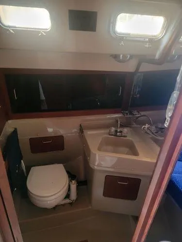 Slide: The Image of 1986 O'Day 35 sailboat bathroom with sink, toilet, and storage cabinets. - 12