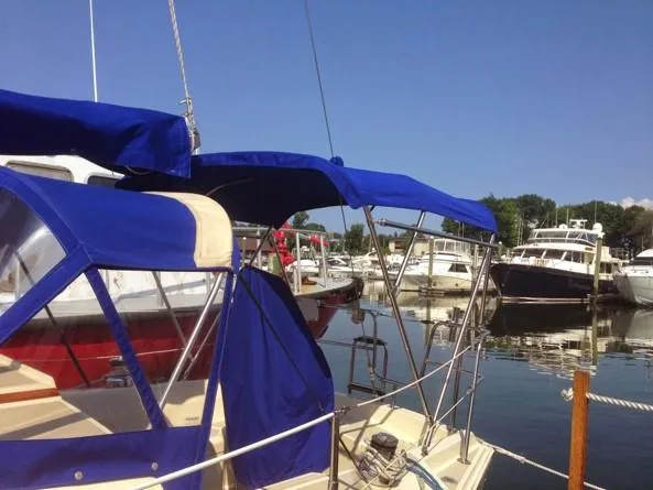 Slide: The Image of 1986 O'Day 35 sailboat with blue canopy docked in a marina. - 5
