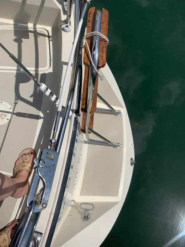 Slide: The Image of 1986 O'Day 35 sailboat deck with wooden trim and railing, docked on calm water. - 6