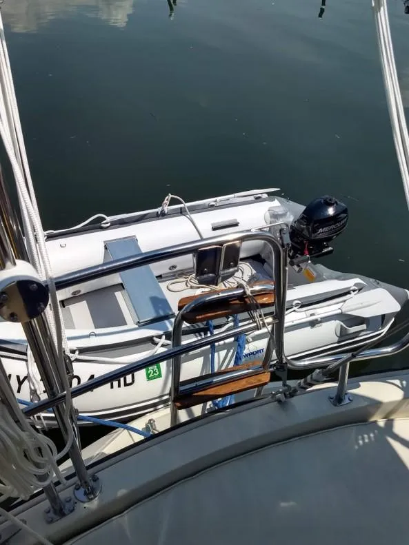 Slide: The Image of 1986 O'Day 35 sailboat with dinghy and outboard motor on calm water. - 7