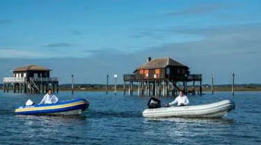 The Image of Two Zodiac Nomad RIB ALU 3.6 NEO boats on water near stilt houses, 2024 model. - 0