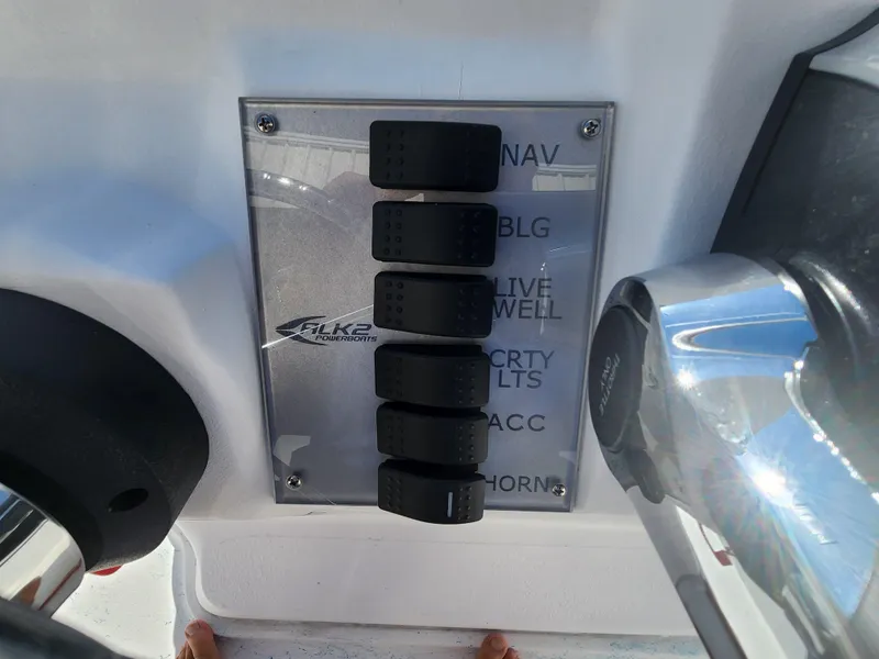 Slide: The Image of Control panel of 2024 ALK2 Powerboats 18 CRS with labeled switches. - 18