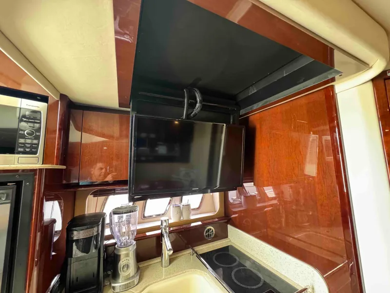 Slide: The Image of Interior kitchen area of 2010 Sea Ray 390 Sundancer yacht with TV, microwave, and appliances. - 23
