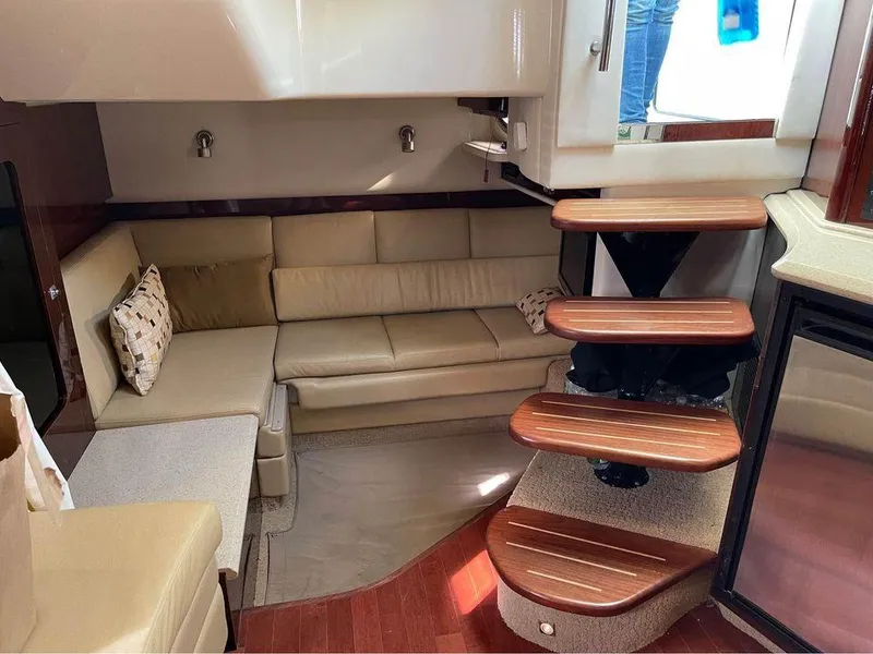 Slide: The Image of Interior of 2010 Sea Ray 390 Sundancer with beige seating and wooden steps. - 25