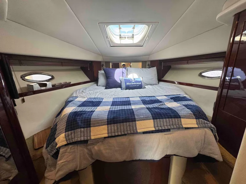 Slide: The Image of 2010 Sea Ray 390 Sundancer cabin with bed, skylight, and portholes. - 26