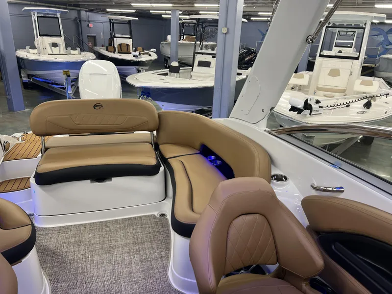 Slide: The Image of Interior of 2024 Crownline 270 XSS boat with tan leather seating in showroom. - 10