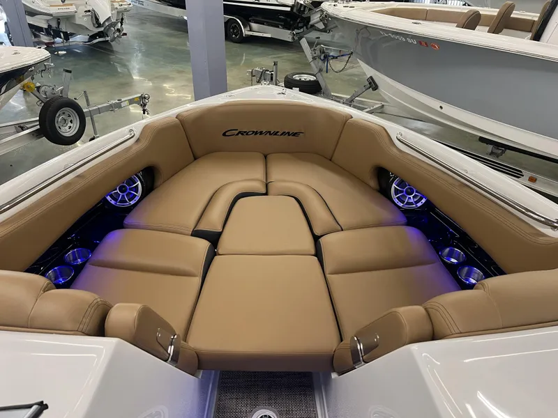 Slide: The Image of 2024 Crownline 270 XSS boat interior with tan leather seating and blue LED lighting. - 6