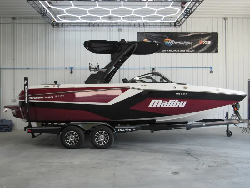 Slide: The Image of 2024 Malibu Wakesetter 23 MXZ boat in showroom, side view. - 1