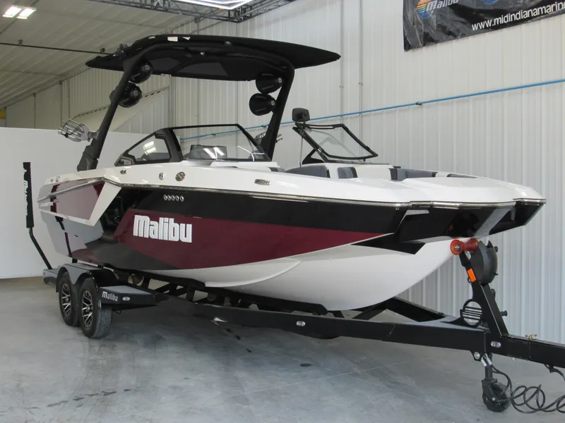 Slide: The Image of 2024 Malibu Wakesetter 23 MXZ boat in showroom, black and white with maroon accents. - 3