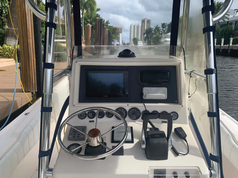 Slide: The Image of 1995 Intrepid 322 Cuddy boat dashboard with steering wheel and navigation equipment. - 4