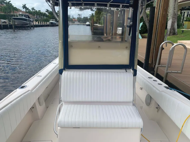 Slide: The Image of 1995 Intrepid 322 Cuddy boat interior with white seating, dockside view. - 7