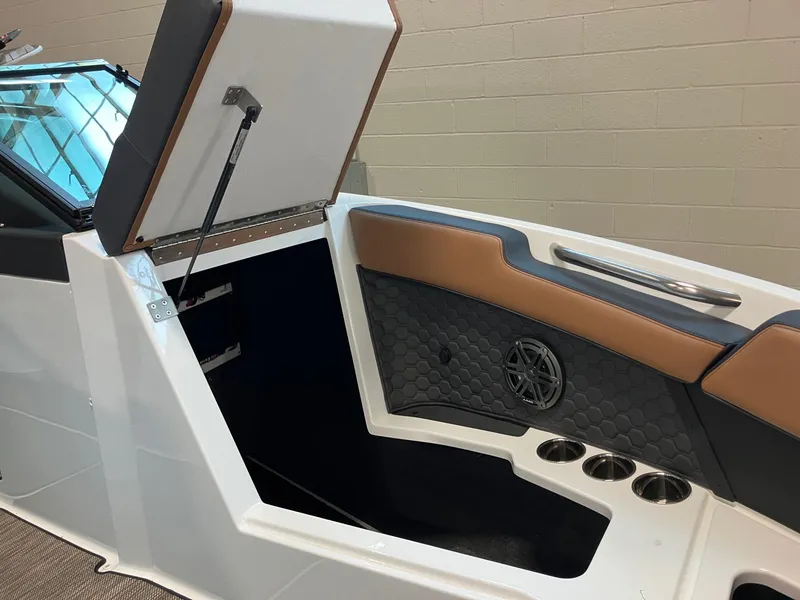 Slide: The Image of 2024 Cobalt R4 Surf boat interior storage compartment with cup holders and cushioned seating. - 15