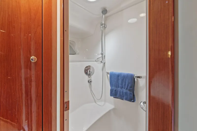 Slide: The Image of 2002 Sea Ray 550 Sundancer shower with wooden door and blue towel. - 18