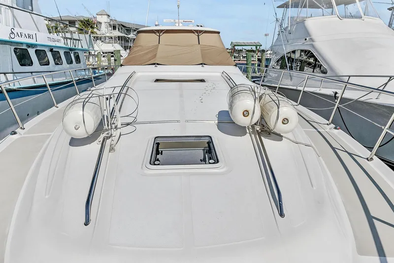 Slide: The Image of 2002 Sea Ray 550 Sundancer yacht deck with safety railings and docked boats. - 3