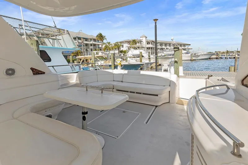 Slide: The Image of 2002 Sea Ray 550 Sundancer yacht with spacious seating area at marina. - 6