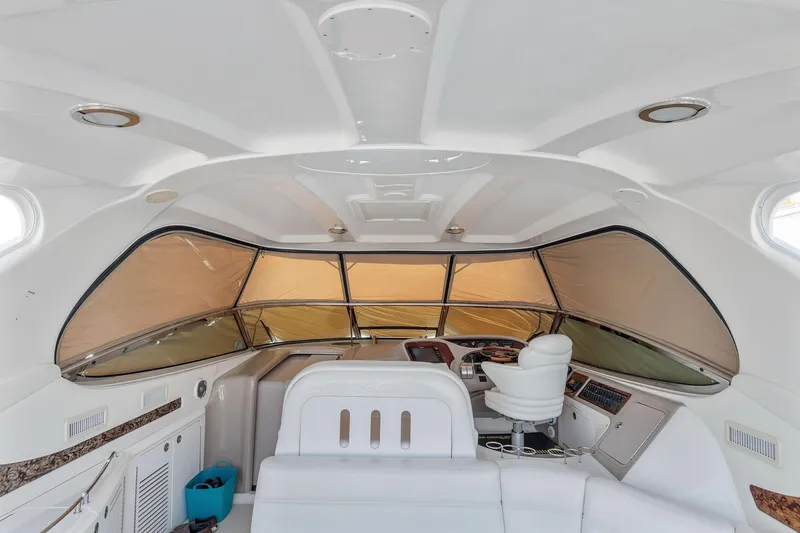 Slide: The Image of Interior helm of 2002 Sea Ray 550 Sundancer yacht with white seating and large windows. - 8