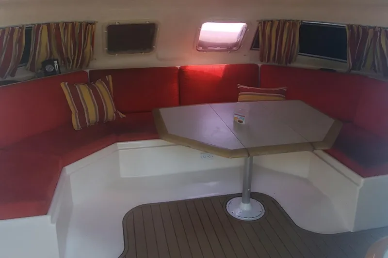 Slide: The Image of Interior of 1992 Fountaine Pajot Antigua 37 catamaran with red seating and striped curtains. - 25