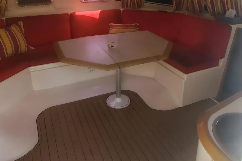 Slide: The Image of Interior seating area of 1992 Fountaine Pajot Antigua 37 catamaran with red cushions and wooden table. - 26