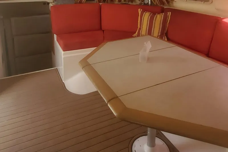 Slide: The Image of Interior seating area of a 1992 Fountaine Pajot Antigua 37 catamaran with red cushions and a table. - 27