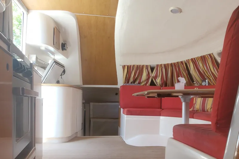 Slide: The Image of Interior of 1992 Fountaine Pajot Antigua 37 catamaran with red seating and striped curtains. - 28