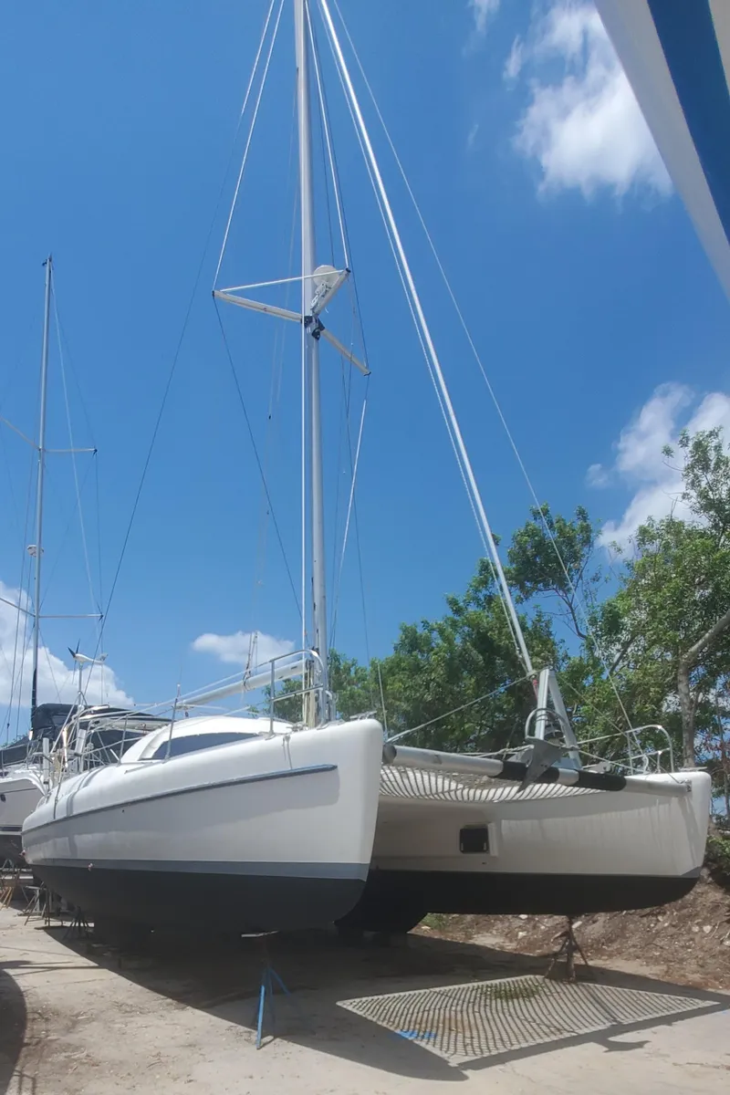 Slide: The Image of 1992 Fountaine Pajot Antigua 37 catamaran on dry dock under a clear blue sky. - 4