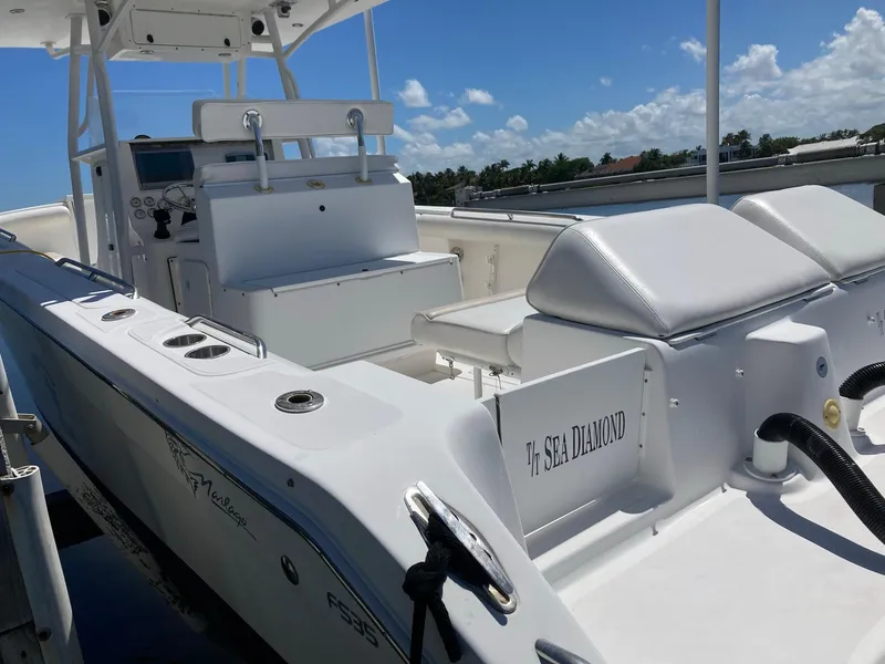 Slide: The Image of 2014 Marlago 35 boat with white seating and console, docked under a clear blue sky. - 17