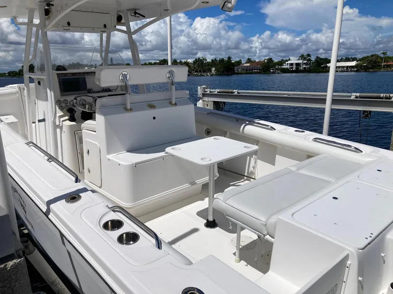 Slide: The Image of 2014 Marlago 35 boat interior with seating and table, docked by the water. - 21