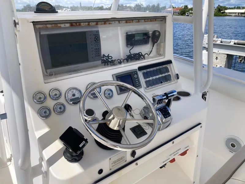 Slide: The Image of 2014 Marlago 35 boat dashboard with steering wheel, gauges, and navigation equipment. - 28