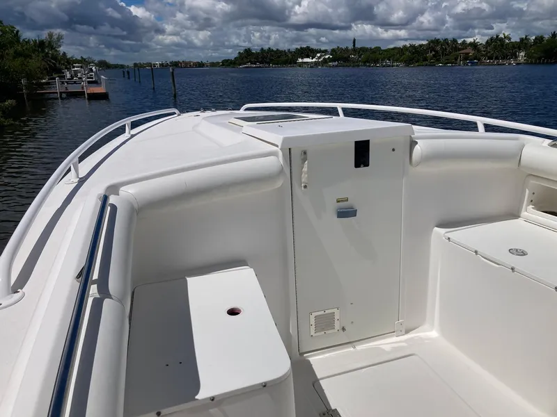 Slide: The Image of 2014 Marlago 35 boat bow with white seating and storage compartments on a sunny day. - 39