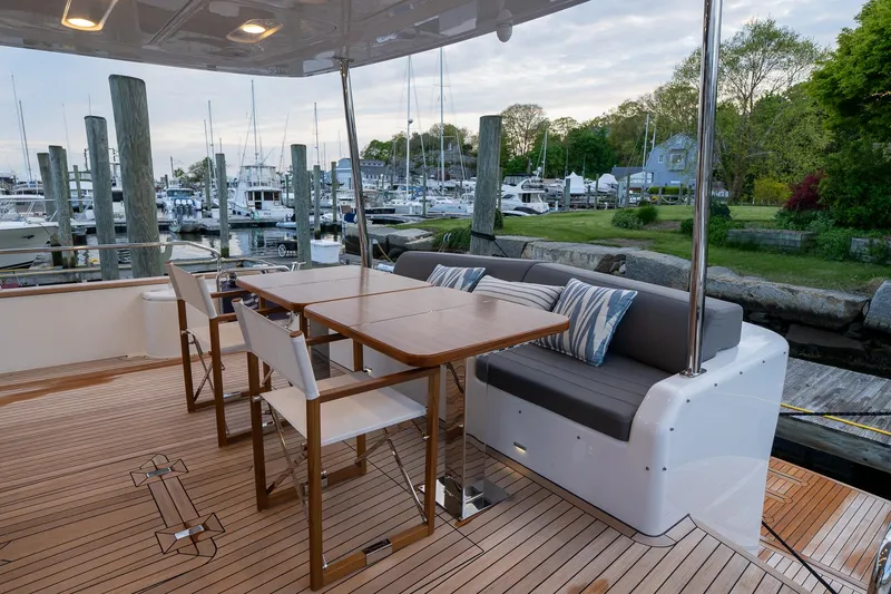 Slide: The Image of 2024 Sirena 58 Flybridge yacht, outdoor seating area with table, docked at marina. - 10