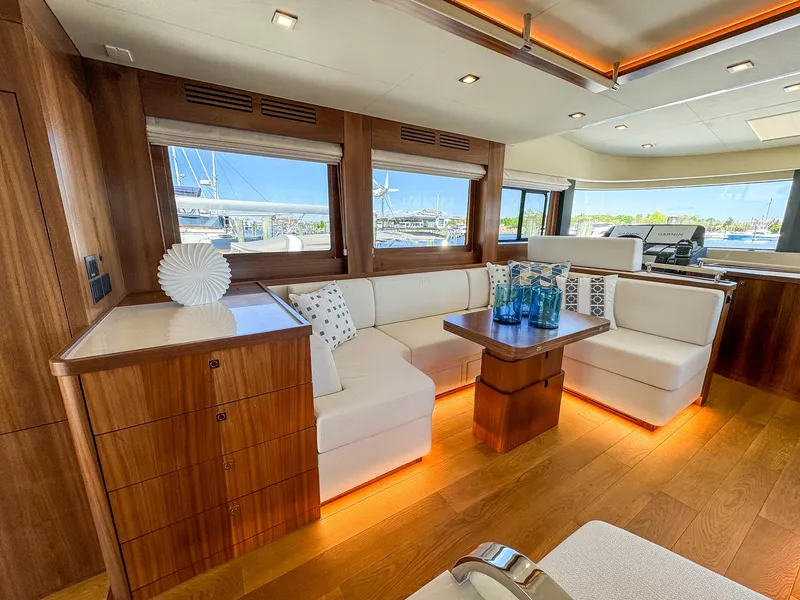 Slide: The Image of 2024 Sirena 58 Flybridge yacht interior with modern wood and white seating. - 44