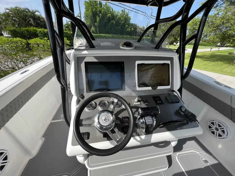 Slide: The Image of 2014 Midnight Express 37 Open boat dashboard with steering wheel and navigation screens. - 24