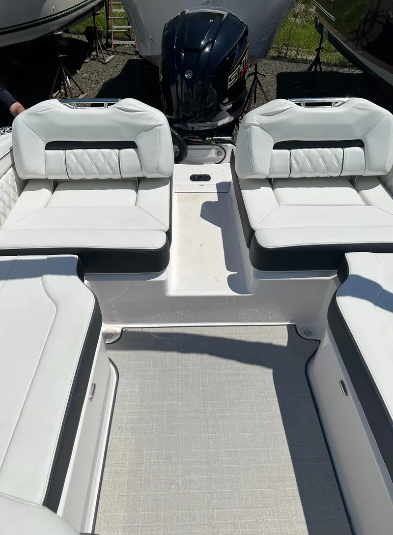Slide: The Image of 2022 Regal LX2 boat interior with white cushioned seating and outboard motor. - 10
