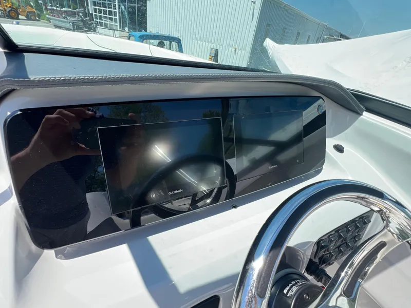 Slide: The Image of 2022 Regal LX2 boat dashboard with dual Garmin displays and steering wheel. - 16