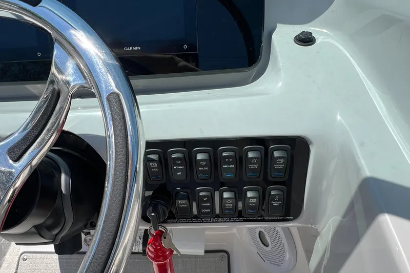 Slide: The Image of 2022 Regal LX2 boat dashboard with steering wheel and control switches. - 17
