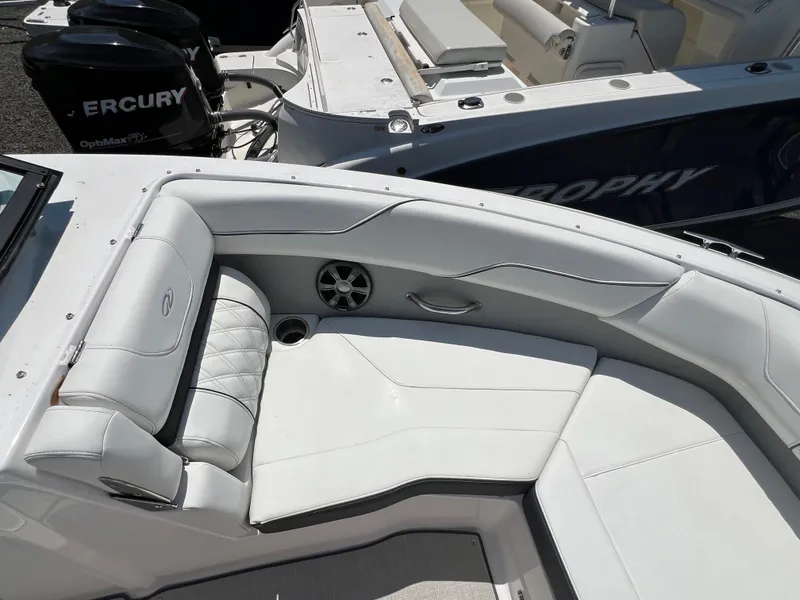 Slide: The Image of 2022 Regal LX2 boat interior with white leather seating and Mercury outboard engines. - 19