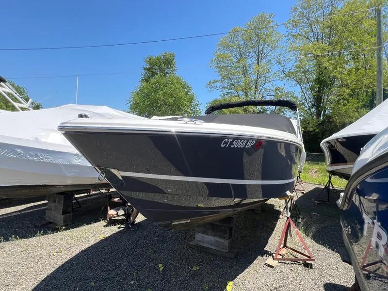 Slide: The Image of 2022 Regal LX2 boat on stands, outdoors, with trees in the background. - 3